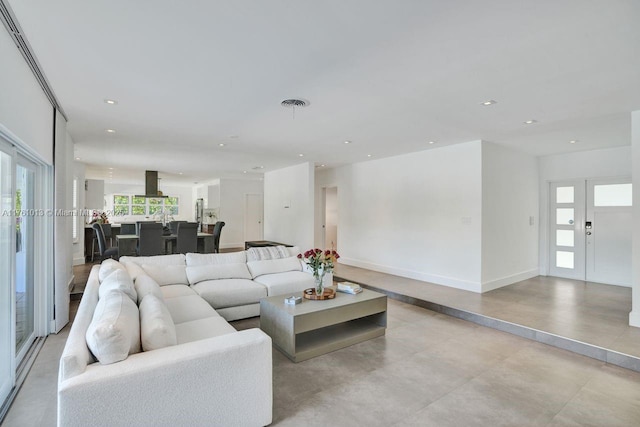 living area with visible vents, recessed lighting, and baseboards