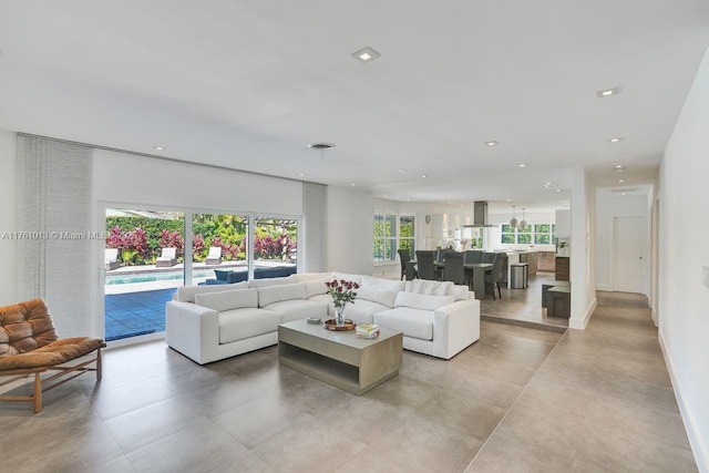 living area featuring recessed lighting and baseboards