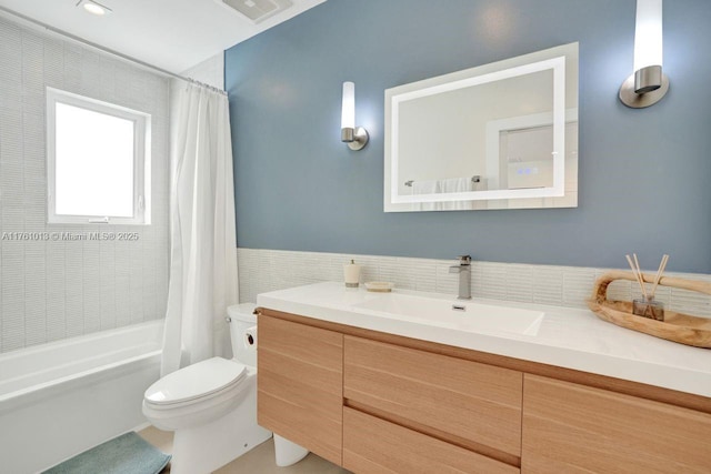 bathroom with vanity, shower / bathtub combination with curtain, visible vents, tile walls, and toilet