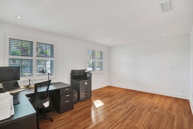 office space with recessed lighting, visible vents, light wood-style flooring, and baseboards