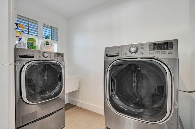 clothes washing area featuring laundry area, baseboards, and separate washer and dryer