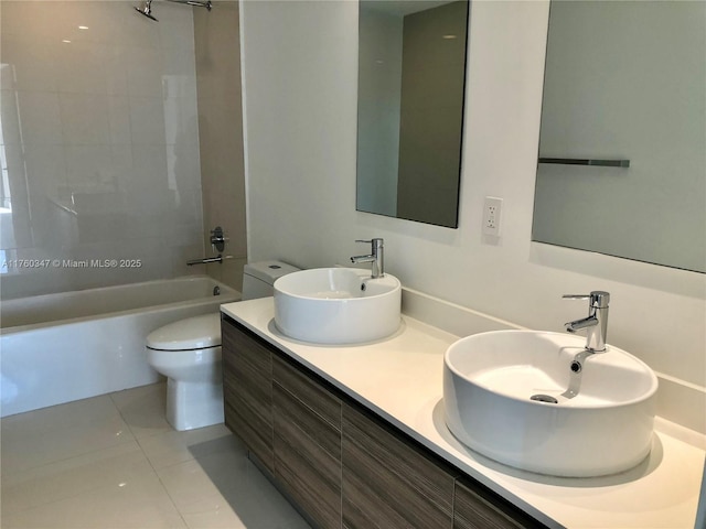 bathroom featuring tile patterned floors, toilet, shower / bathtub combination, and a sink