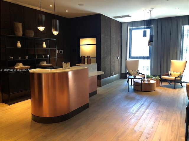 bar with visible vents, pendant lighting, and light wood-style flooring