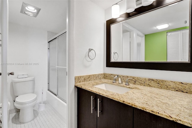 full bathroom with bath / shower combo with glass door, toilet, vanity, and tile patterned flooring