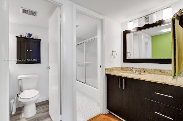 full bathroom with visible vents, toilet, wood finished floors, and vanity