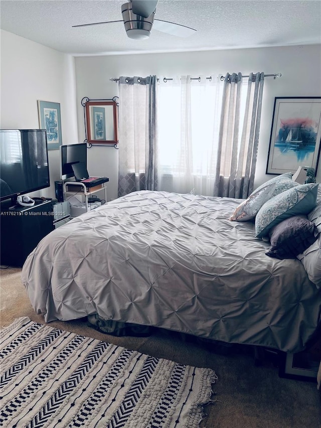 bedroom featuring ceiling fan, carpet flooring, and a textured ceiling