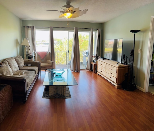 living room featuring wood finished floors, baseboards, and ceiling fan