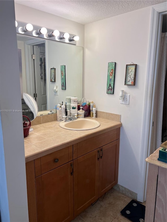 bathroom with vanity, tile patterned floors, and a textured ceiling