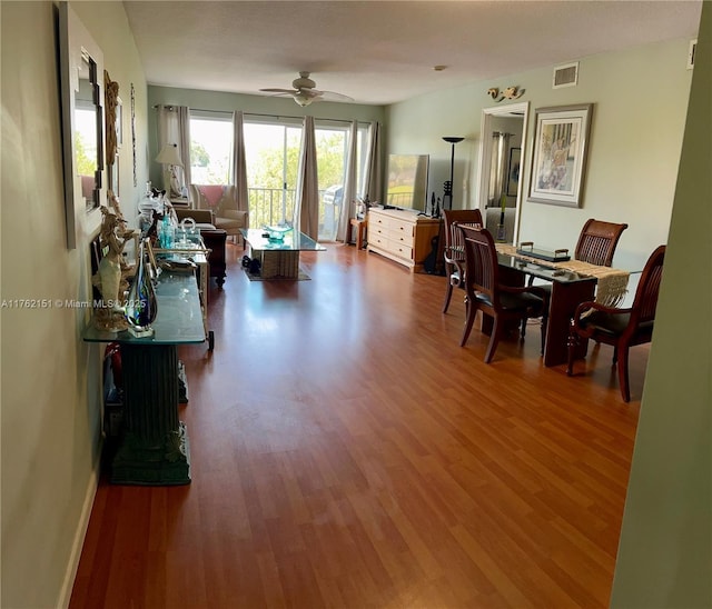 dining space featuring visible vents, baseboards, a ceiling fan, and wood finished floors