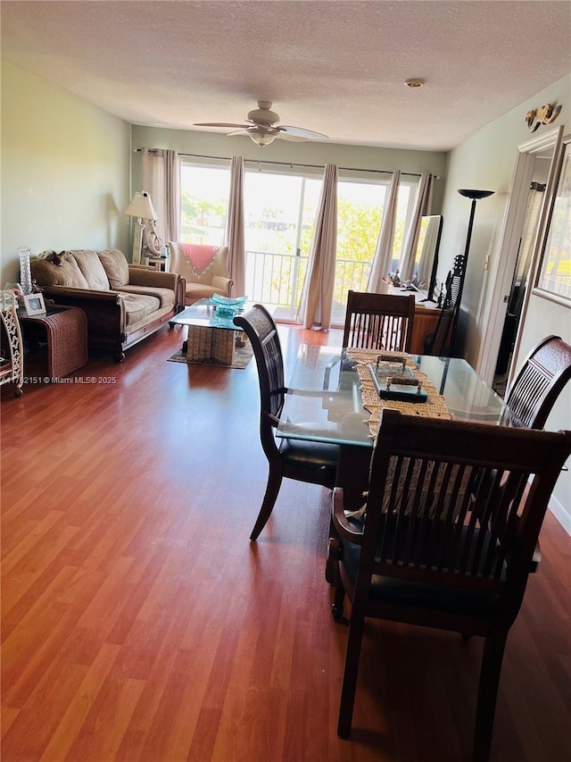 dining room with ceiling fan, a textured ceiling, and wood finished floors