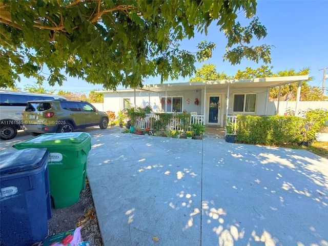 ranch-style house with a porch and fence