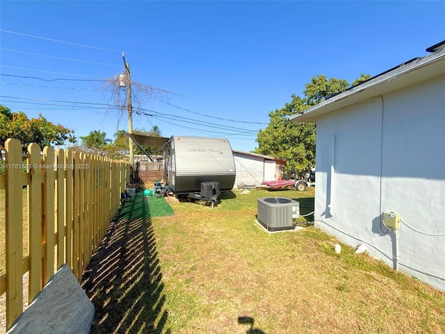 view of yard with central AC unit and fence