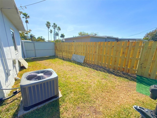 view of yard featuring central AC and fence