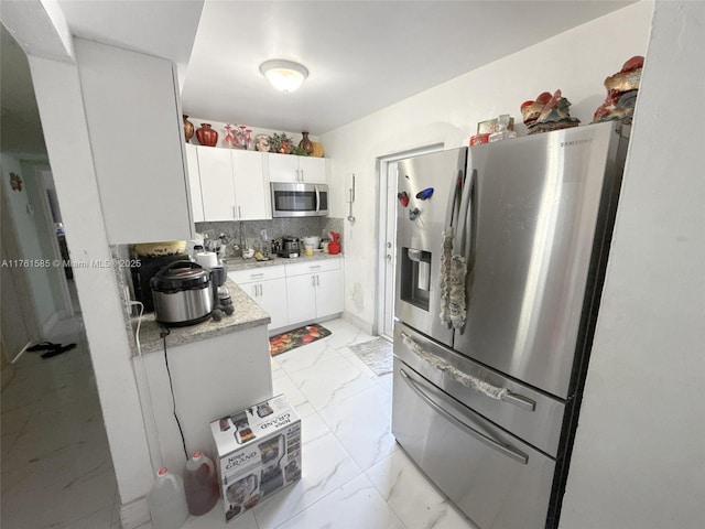 kitchen featuring backsplash, marble finish floor, white cabinets, and stainless steel appliances