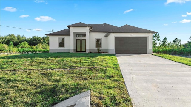 prairie-style home with concrete driveway, a garage, a front yard, and stucco siding