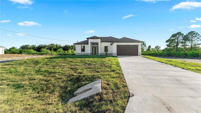 prairie-style house featuring stucco siding, an attached garage, driveway, and a front lawn