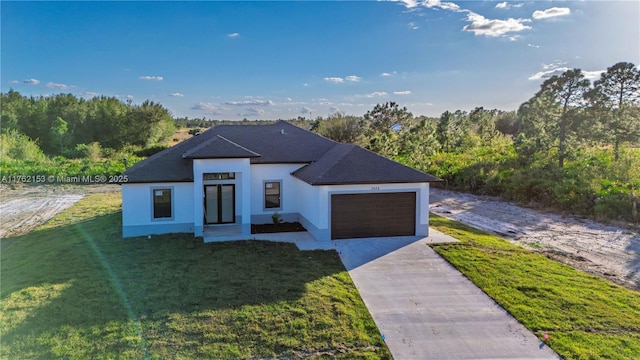 view of front of property with stucco siding, driveway, an attached garage, and a front yard