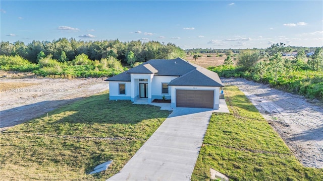 view of front of house featuring stucco siding, a front lawn, an attached garage, and driveway