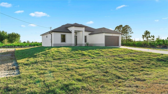 prairie-style home featuring a garage, a front yard, driveway, and stucco siding