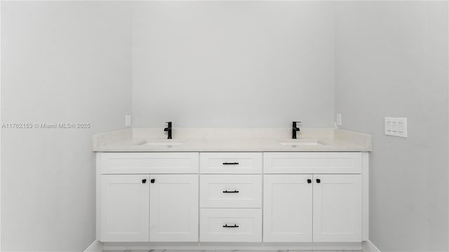 bathroom with a sink, baseboards, and double vanity