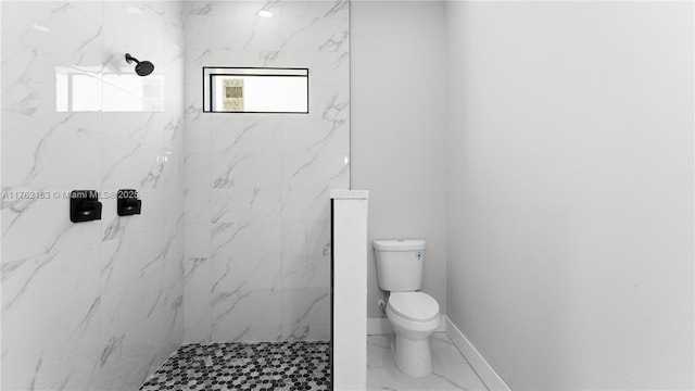 bathroom featuring a marble finish shower, marble finish floor, toilet, and baseboards