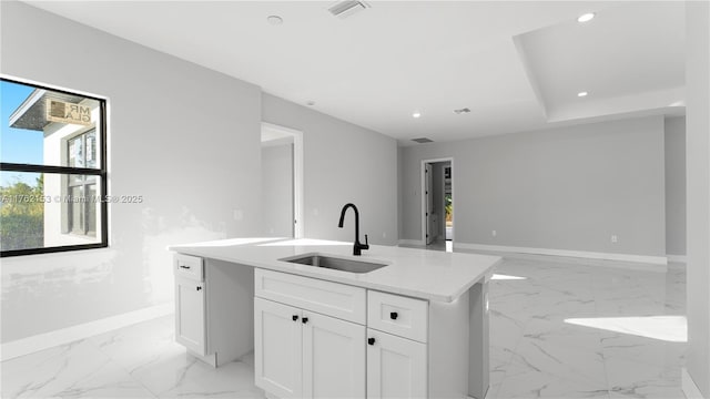 kitchen with baseboards, visible vents, recessed lighting, a sink, and white cabinets