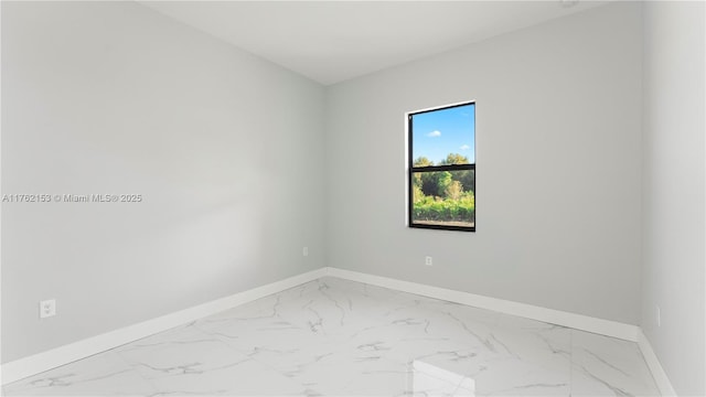 empty room featuring baseboards and marble finish floor