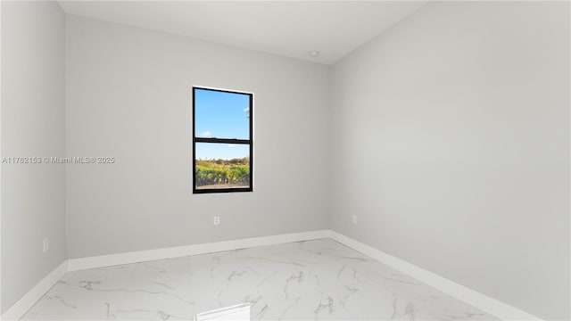 unfurnished room featuring baseboards and marble finish floor