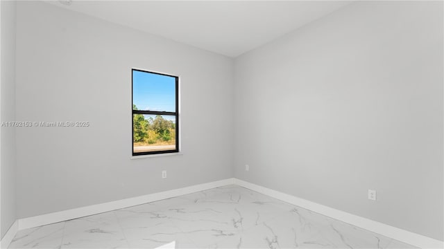 empty room featuring baseboards and marble finish floor