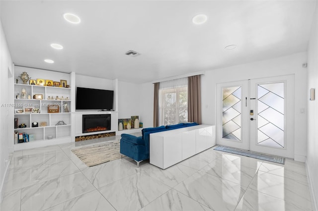 living area with visible vents, marble finish floor, recessed lighting, french doors, and a lit fireplace