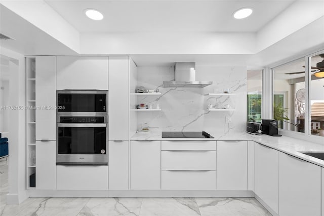 kitchen with modern cabinets, white cabinets, wall chimney range hood, black electric stovetop, and light stone countertops