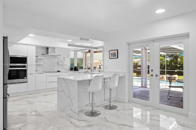 kitchen featuring white cabinets, modern cabinets, marble finish floor, and stainless steel appliances