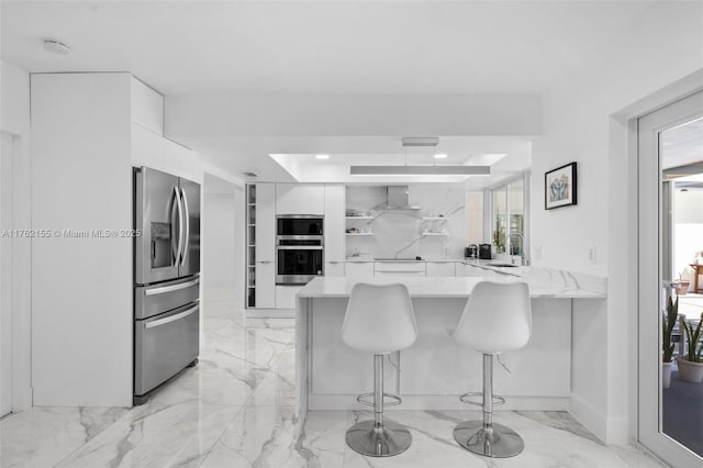 kitchen with white cabinetry, a peninsula, modern cabinets, and appliances with stainless steel finishes