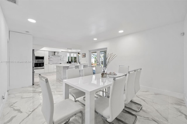 dining space with recessed lighting, marble finish floor, and baseboards