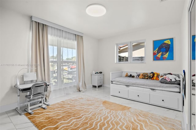 bedroom featuring marble finish floor and multiple windows