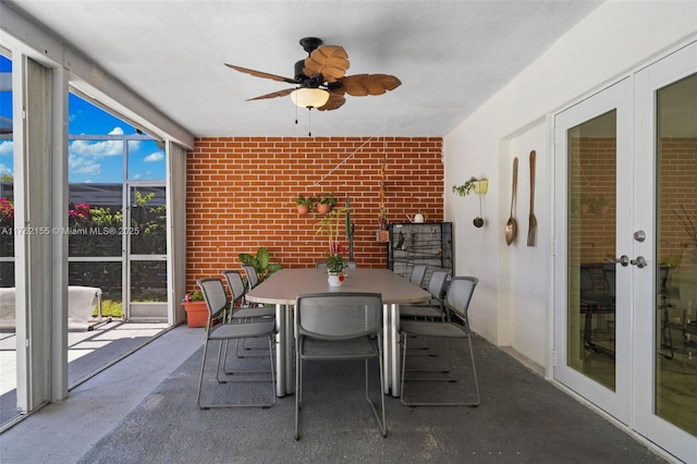 unfurnished sunroom with a ceiling fan and french doors