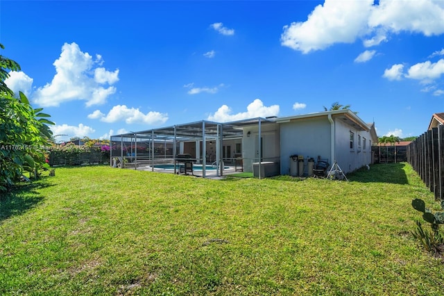 rear view of property with stucco siding, a lawn, a fenced backyard, an outdoor pool, and a lanai