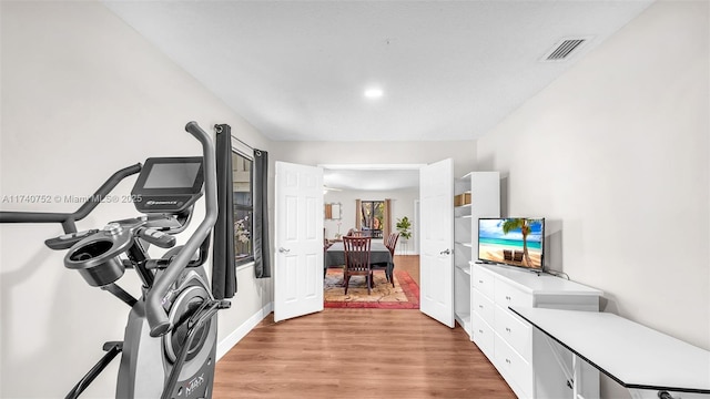 interior space featuring baseboards, visible vents, and light wood finished floors