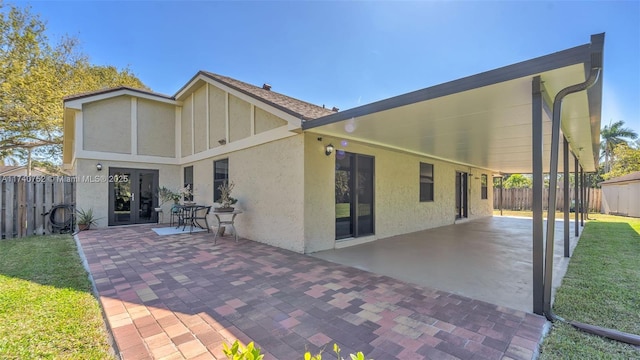 back of property with a patio, fence, french doors, and stucco siding