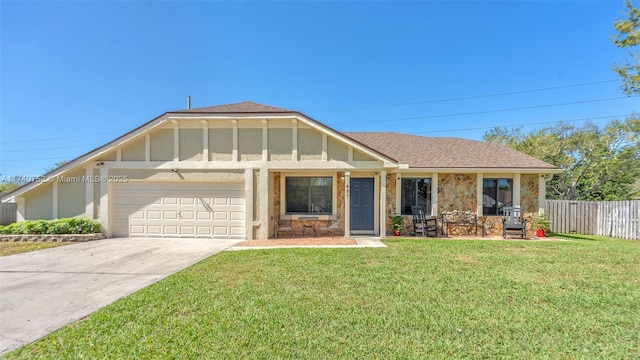 view of front of home with driveway, a front lawn, fence, an attached garage, and a shingled roof