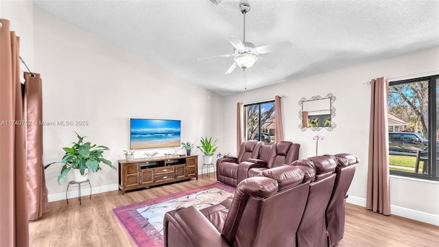 living area featuring vaulted ceiling, light wood-style floors, and a wealth of natural light