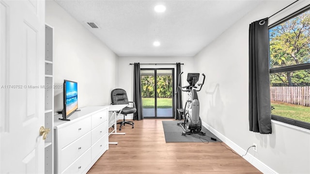 workout area with visible vents, recessed lighting, baseboards, and light wood-style floors