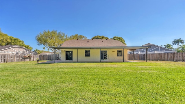 back of property with a patio, a yard, a fenced backyard, and stucco siding