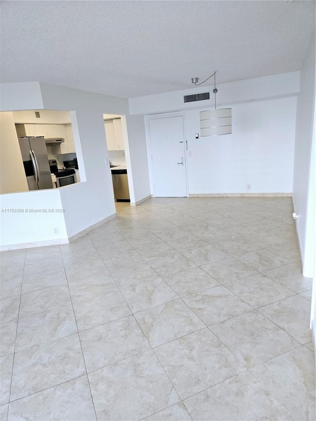 unfurnished living room with baseboards, visible vents, and a textured ceiling