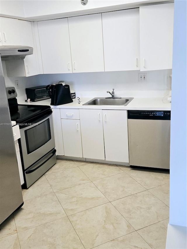 kitchen with under cabinet range hood, light countertops, appliances with stainless steel finishes, white cabinets, and a sink