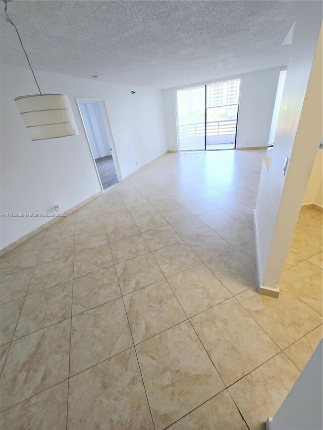 3300 NE 191st St Unit 609, Aventura, FL 33180 - spare room featuring a textured ceiling and light tile patterned flooring