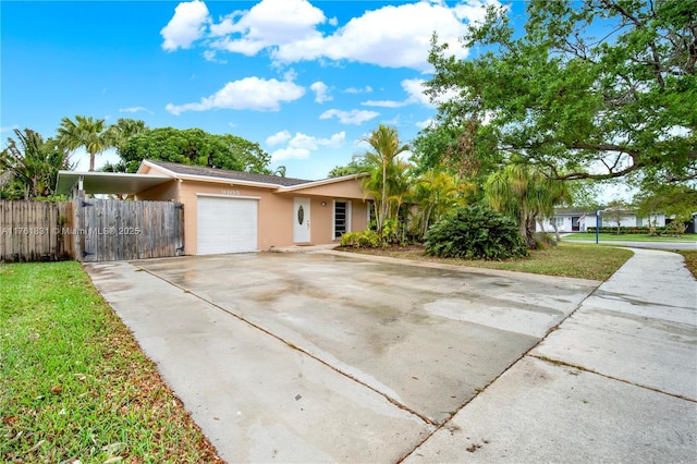 view of front facade featuring a front yard, fence, driveway, an attached garage, and stucco siding