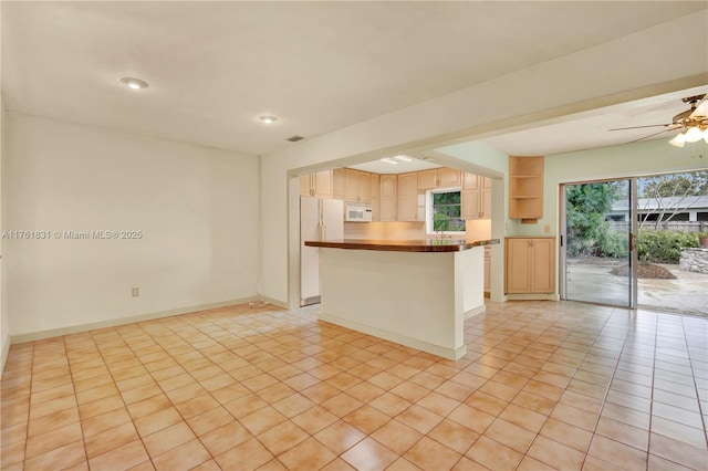 kitchen featuring white appliances, plenty of natural light, light brown cabinets, and baseboards