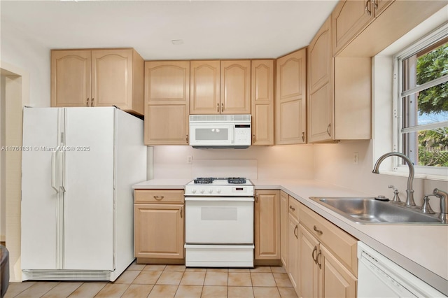 kitchen featuring light brown cabinets, white appliances, light countertops, and a sink