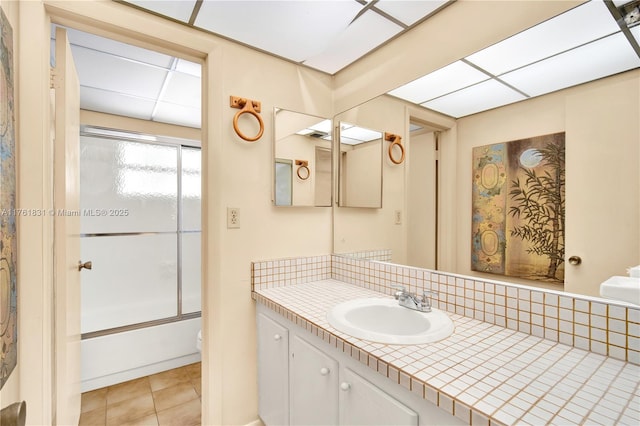 bathroom featuring vanity, enclosed tub / shower combo, decorative backsplash, tile patterned floors, and toilet